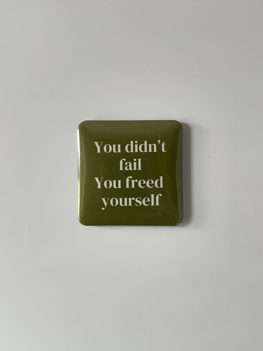 Green fridge magnet with text “ You didn’t fail, you freed yourself” against a white background