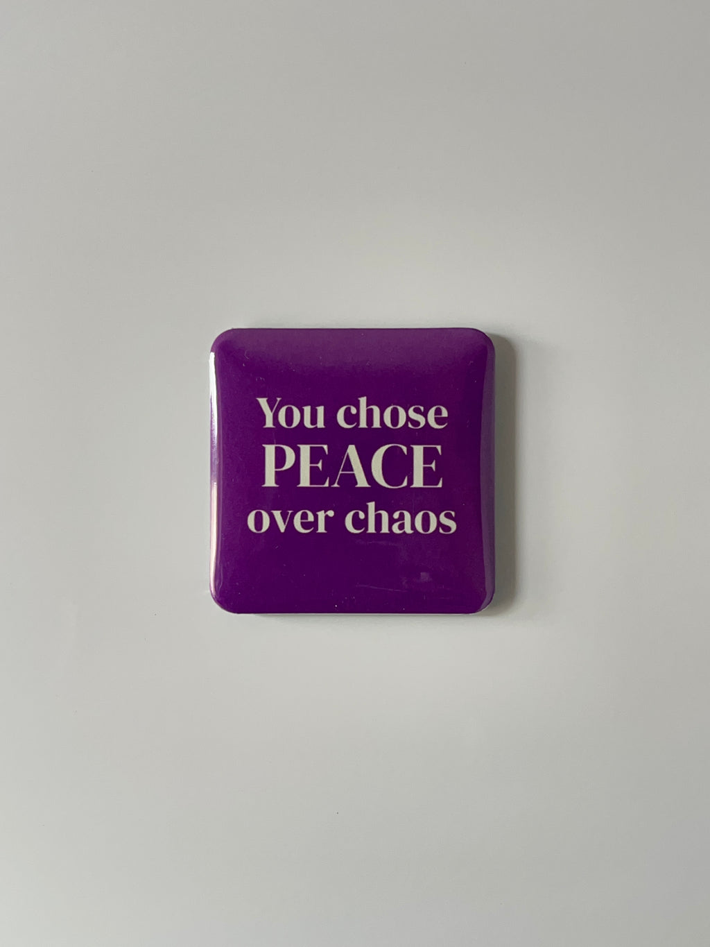 Purple fridge magnet with text 'You chose PEACE over chaos' on a light gray background