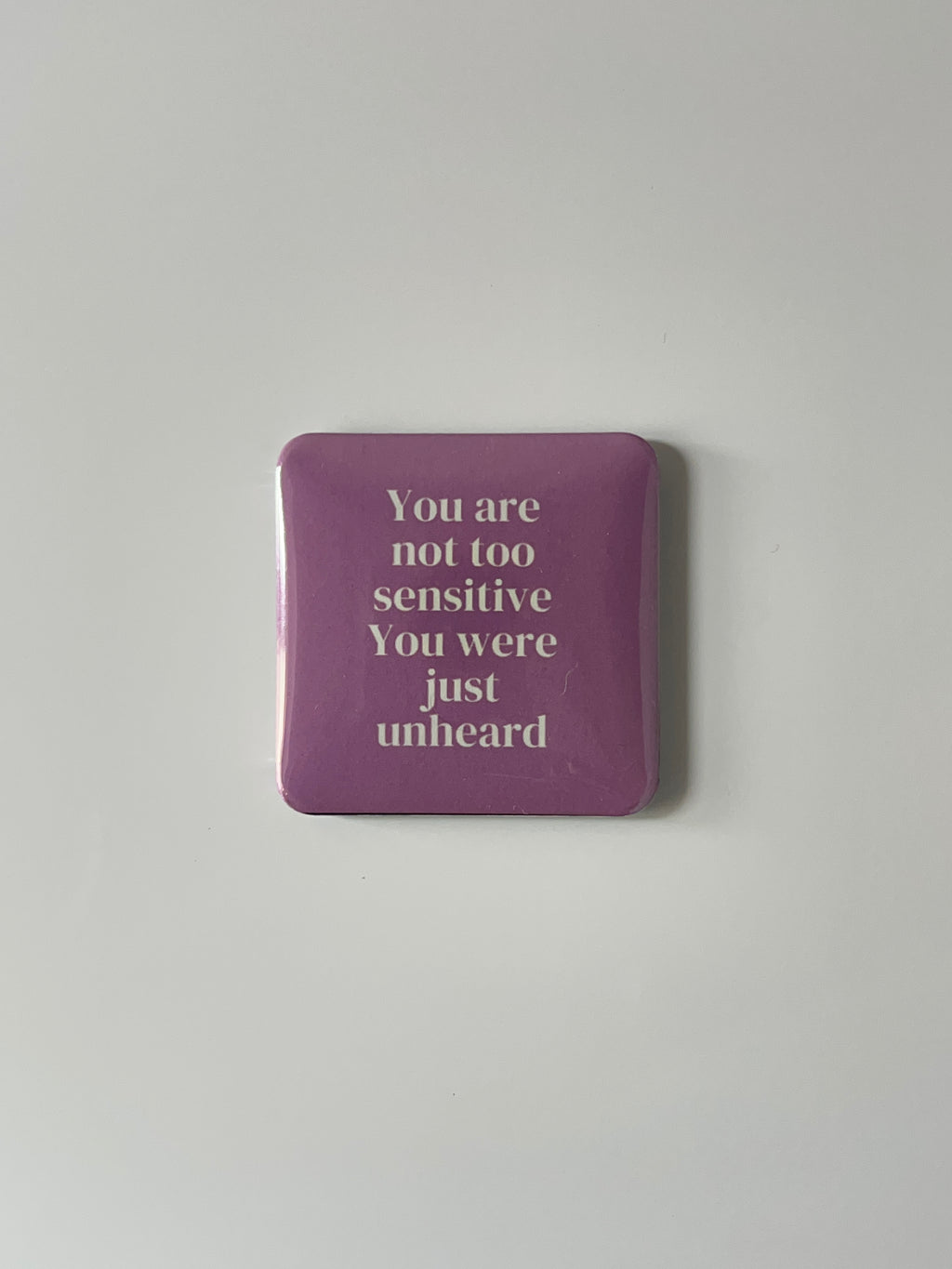 Pink fridge magnet with text “ You are not too sensitive” on a white background