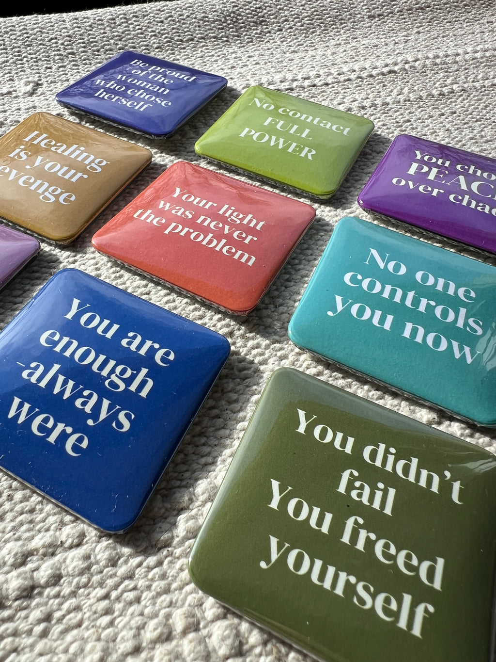 Motivational phrase on fridge magnets in various colors on a textured surface