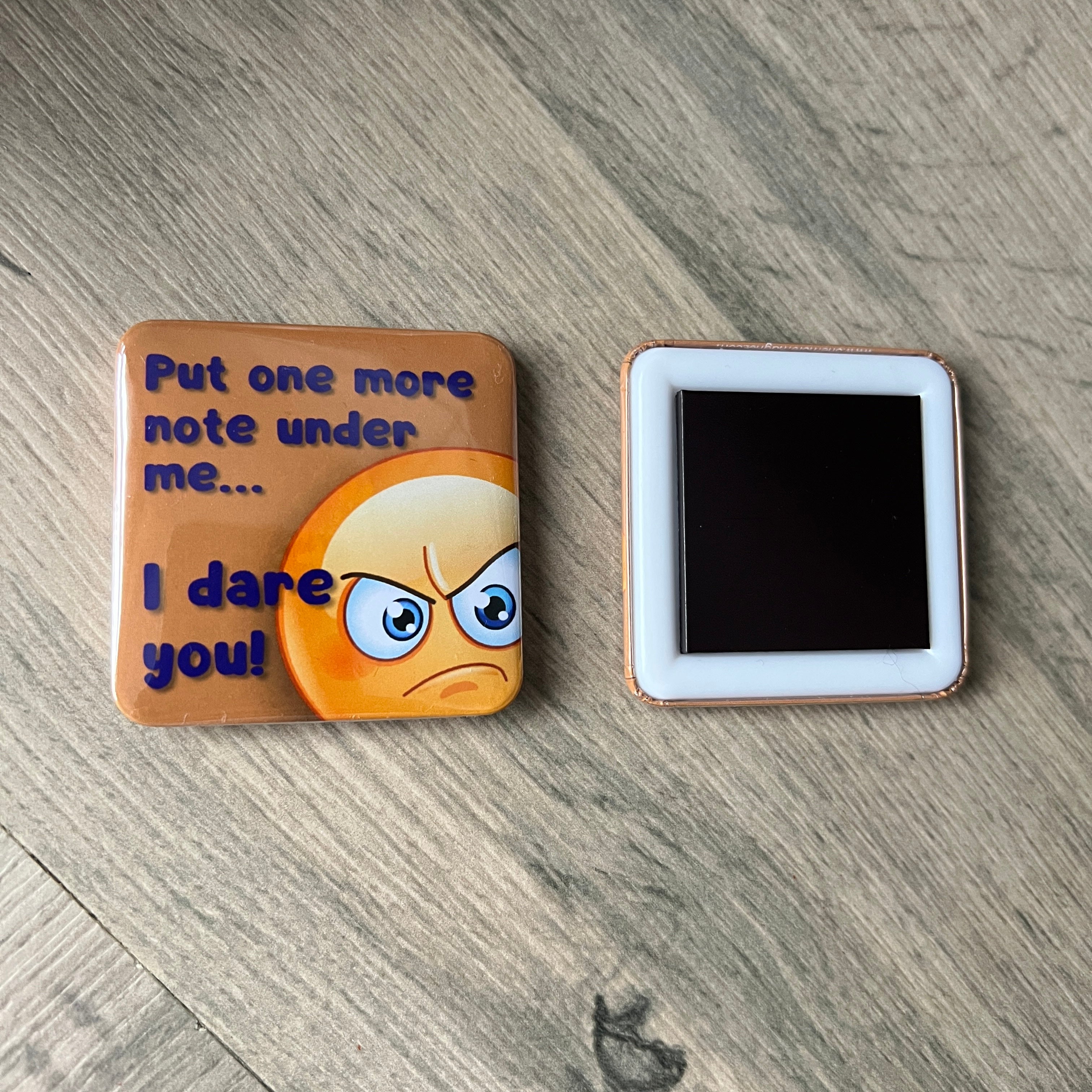 Emotional emoji magnet with text on a wooden surface